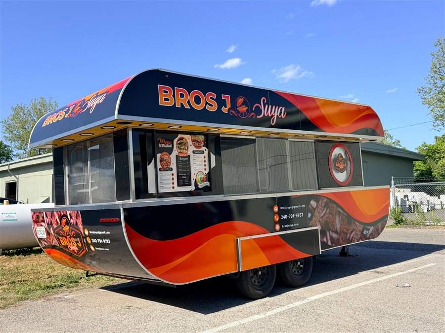 Bros J Suya black and orange BBQ trailer with bold flame graphics and menu board